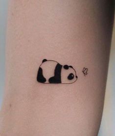 a small panda bear tattoo on the right side of the leg, it is black and white