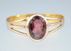 A gorgeous antique Victorian 18k yellow gold and 9k rose gold garnet solitaire ring, dating to circa 1880. This attractive antique Victorian ring has a solid 18k yellow gold band with a solid 9k rose gold head and shoulders, the ring with a beautiful 2/3 carat oval faceted bezel-set natural garnet which glows a glorious deep red with hints of pink, the garnet set in a closed rose gold gallery raised above stylish tri-split shoulders leading to a wide classic yellow gold band-lovely! The ring is Victorian Rings Antique, Antique Rings Victorian, Gold Gallery, Victorian Ring, Victorian Rings, Red Band, 3 Carat, Gold Band, Antique Rings