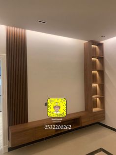 an empty room with a book shelf and yellow clock on the wall next to it