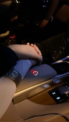 two people holding hands while sitting in a car