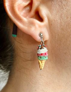 a woman wearing earrings with an ice cream cone hanging from it's back end