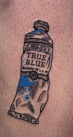 a tattoo on the back of a man's shoulder with a blue liquid bottle in it