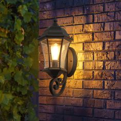 an outdoor light on the side of a brick wall