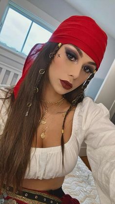 a woman with long hair wearing a red bandana and gold chains on her head