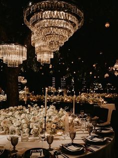 the table is set up for an event with chandeliers hanging from the ceiling