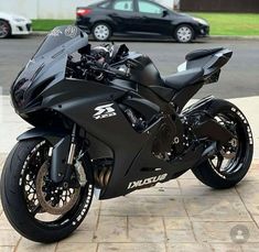 a black motorcycle parked in front of a car