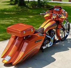 an orange motorcycle parked on top of a sidewalk