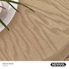 a close up of a plate on a table with a plant next to it and an ad for minwax