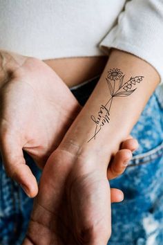 a woman's arm with a flower tattoo on her left wrist, and the word faith written in cursive writing