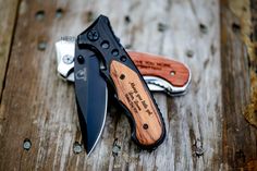 two knives sitting next to each other on top of a wooden table