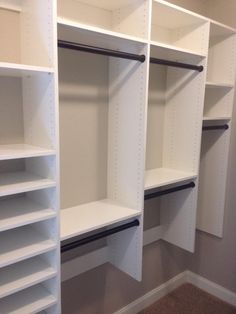 an empty walk in closet with white shelving