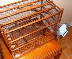 a bird cage sitting on top of a wooden table