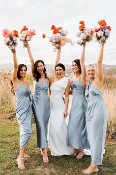 the bridesmaids are holding their bouquets in the air and smiling at the camera