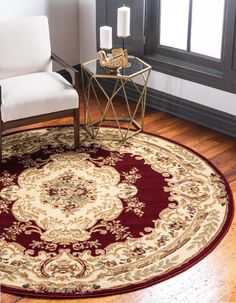 a living room area with a chair, table and rug on the hardwood flooring