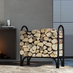 a stack of logs sitting in front of a fire place next to a wall mounted fireplace