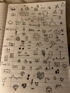 a notebook with some doodles on it and various symbols drawn in the paper next to each other