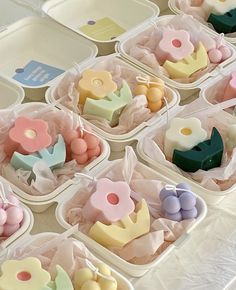 small plastic trays filled with different types of candies on a white tablecloth