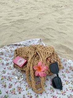 a purse and sunglasses are laying on the beach