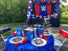 a table set up with plates, cups and napkins for a wwe birthday party