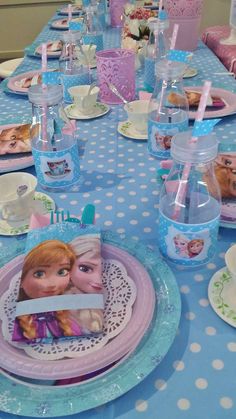 the table is set with plates, cups and napkins for a frozen princess birthday party