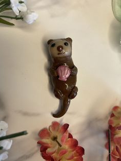 there is a bear figurine and flowers on the table