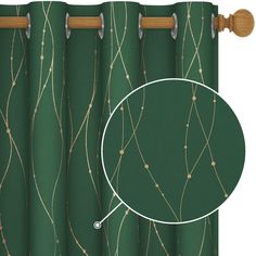 a green curtain with gold lines on it and a round hole in the middle that has a wooden rod