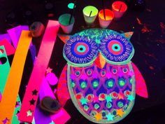 an owl made out of colored paper surrounded by other crafting supplies and candles on a table