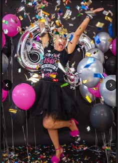 a woman standing in front of balloons and confetti