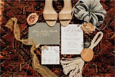 an assortment of wedding items including shoes, ties and flowers on a carpeted area