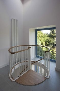 a spiral staircase in a house with large windows