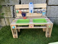 an outdoor table made out of pallet wood with green bowls and plates on it