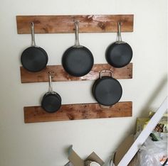 pots and pans are hanging on a wooden rack