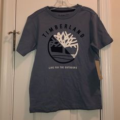 Brand New Timberland Boys T-Shirt! In The Color Blue And In The Size 8! Blue Short Sleeve T-shirt For Outdoor, Outdoor Blue Cotton Tops, Blue Cotton Tops For Outdoor, Blue Cotton Outdoor T-shirt, Outdoor Blue Cotton T-shirt, Outdoor Blue T-shirt With Letter Print, Blue Graphic Print Top For Outdoor, Timberland T Shirt, Timberland Logo