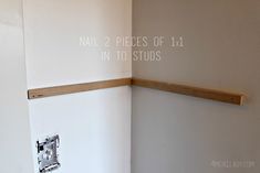 the corner of a room with two pieces of wood on it and text overlaying that says nail 2 pieces of 11 in to studs