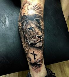 a man's leg with a lion and cross tattoo on it