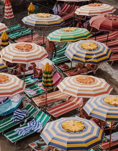 many people are sitting under umbrellas on the beach