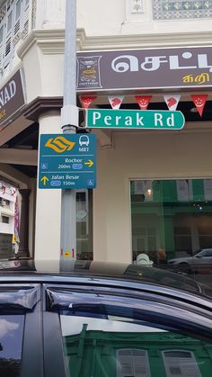 a car parked in front of a building with street signs on it's side