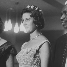 an old black and white photo of three women in formal dress standing next to each other