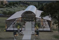 an outdoor wedding venue set up in the middle of a field with greenery and candles