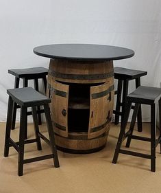 a wooden barrel table with stools around it