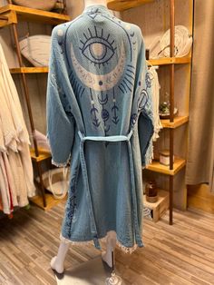 LIGHT BLUE ETHNICAL EYE AND MOON KIMONO - COVER UP KIMONO - ROBE Welcome to Tutunaki, where elegance meets nature in our unique collection of handcrafted kimonos. Indulge in the beauty of our artisanal creations, meticulously crafted from organic muslin fabric. Each boho kimono is a masterpiece, adorned with vibrant patterns delicately embroidered using the wood printing technique, capturing the essence of movement and vitality. Our kimonos are more than just garments; they're a celebration of natural beauty and harmony with nature. Made from organic cotton, they offer exceptional softness and breathability, ensuring comfort in all seasons. Whether you wear them as dressing gowns, at the pool, beach, or spa, or as statement pieces at festivals and parties, our kimono robes embody both styl Moon Kimono, Cover Up Kimono, Wood Printing, Boho Robes, Robe Women, Dressing Gowns, Cotton Kaftan, Moon Pattern, Kimono Pattern