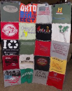 a quilt made out of t - shirts hanging on a wall