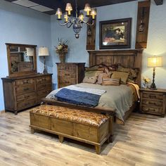 a bed room with a neatly made bed and dressers