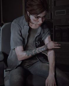 a person sitting in a chair with tattoos on their arms and arm, looking down