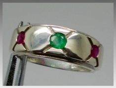 HI The center stone of this ring is a natural, earth mined, colombian emerald, 3.5 mm, round shape, SI clarity, 0.12 carats. The stones on the sides are 2 natural rubies, 2.7 mm, round shape, 0.20 cttw, vs clarity. The ring is made in 14kt solid gold, and the weight is 7 grams. I have 3 of this rings, one in white, one in yellow, and one in rose gold. The size of the rings is 9.75, I offer change the size of the ring to any size from 4 to 14 with no extra charge, so if you are getting one of the Round Multi-stone Emerald Ring, Multi-stone Round Cut Emerald Ring, Emerald Multi-stone Round Cut Ring, Round Cut Multi-stone Emerald Ring, Luxury Men's Fine Jewelry Emerald Ring, Mens Real Ruby Rings, Mens Ruby Ring Silver, Luxury Handmade Men's Ruby Ring, Luxury Polished Finish Men's Ruby Ring