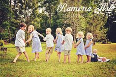 a group of young children standing next to each other on top of a grass covered field