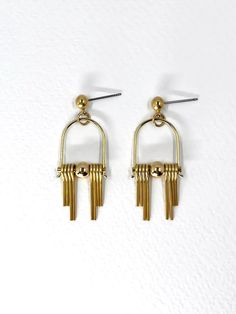 These Art Deco inspired earrings feature sleek, modern design elements, highlighting the radiant golden brass. Each earring boasts a distinctive arched geometric shape inspired by the Art Deco style, lending a sense of elegance and sophistication.  The stepped cut brass fringe creates movement and shine and adds to the uniqueness and contemporary design.  Their minimalist yet bold design embodies a harmonious balance between simplicity and intricacy, making them a versatile accessory suitable for both formal occasions and everyday wear. Each earring is finished with a brass ball stud with stainless steel post. Approximate measurements- 4.5 long 1.5cms wide These earrings are available in three variations- -Black Agate semi precious stone -Green Agate semi precious stone  -All Brass Please Modern Gold-tone Drop Linear Earrings, Modern Gold-tone Linear Drop Earrings, Modern Gold-tone Linear Earrings, Modern Gold Metal Chandelier Earrings, Modern Gold Geometric Earrings, Modern Gold Linear Earrings For Pierced Ears, Modern Yellow Gold Linear Earrings, Modern Geometric Gold Earrings, Modern Gold-tone Dangle Linear Earrings