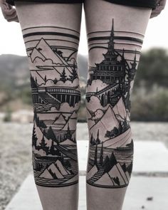 a woman's legs with tattoos on them, and mountains in the sky behind her