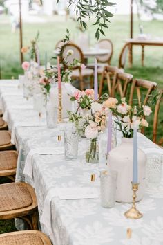 a long table with flowers and candles on it