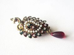 A beautiful peacock shape jewelry designed to be attached on dress or saree, often to hold them close. This lovely peacock shaped metal brooch has a glamorous golden look and is set with elegant white rhinestones and green and red elements. This one of a kind brooch ornament will add instant glamour and sophistication to any outfit. Measures: 2.5 by 1 inches approx The Pin is very good quality so perfect gathering lots of material. Lots of other designs available in my shop! Will be packaged well to ensure safe arrival! PAYMENT We Request buyers to please USE PayPal as a first payment option, all major Credit Cards and Debit Cards are accepted through PayPal. Color variations possible due to individuals different screen settings. Elegant Party Brooch With Peacock Design, Wedding Brooch With Peacock Design, Elegant Peacock Design Brooch For Wedding, Elegant Wedding Brooch With Peacock Design, Elegant Peacock Design Wedding Brooch, Elegant Peacock Brooches For Wedding, Peacock Colored Wedding Brooch Jewelry, Elegant Peacock-colored Brooches For Wedding, Elegant Peacock Color Wedding Brooches